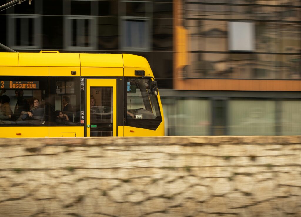 Vibrant yellow tram in motion through Sarajevo's historic streets in Bosnia and Herzegovina.