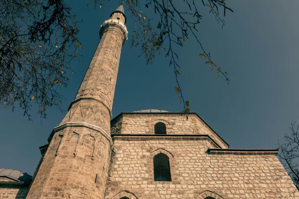 pexels-photo-15080907-15080907 Low angle view of a mosque minaret in Sarajevo with clear blue sky.