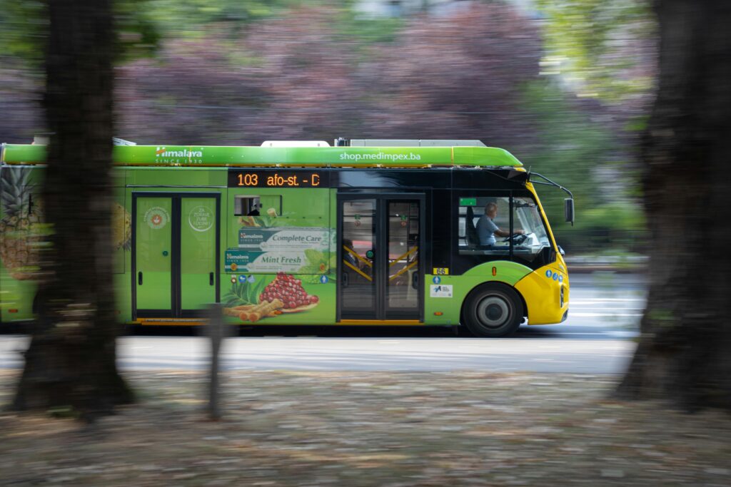 Bright green trolleybus captured moving swiftly through Sarajevo, Bosnia and Herzegovina.