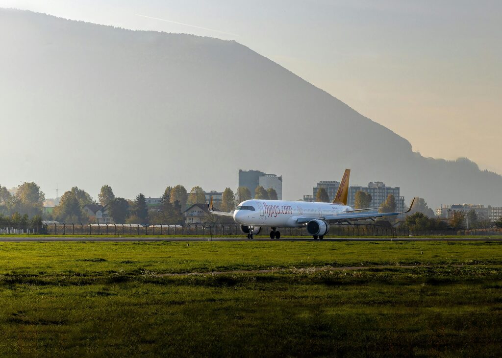 pexels-photo-29233329-29233329 Commercial airplane on a runway against a scenic mountain landscape in Sarajevo.