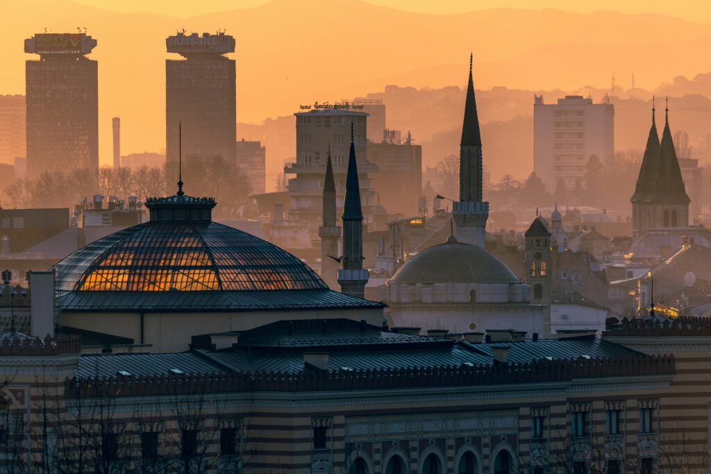 pexels-photo-36707003-36707003 Captivating skyline view of Sarajevo as the sun sets, highlighting iconic spires and domes.