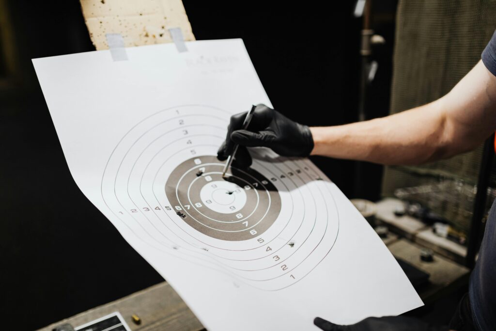 pexels-photo-5202442-5202442 Close-up of a person marking hits on a shooting range target with a marker.